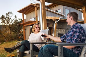 Couple enjoying mountain view from a luxury cabin at sunset in Colorado.