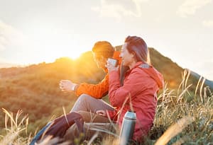 couple on mountainside at sunset