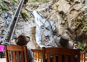 Tourists Sitting On Chair At Seven Falls In Colorado Springs