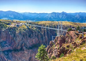 summer time view of Royal Gorge and bridge with mountains in distance