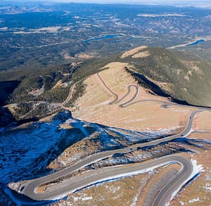 aerial view of pikes peak highway with snow along road