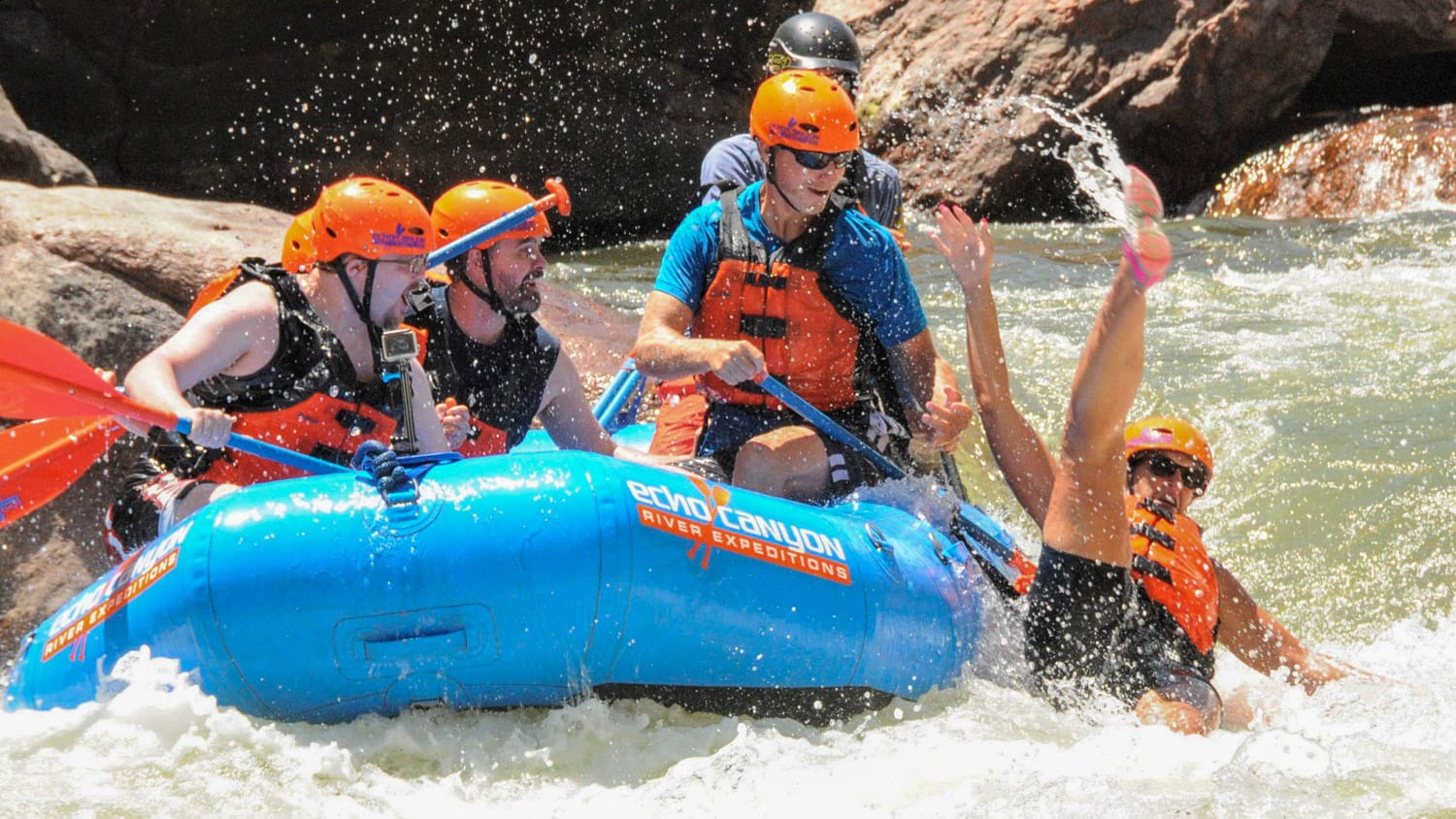 a rafter falls out of a raft in a rapid