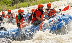 First-time rafters paddling a Class III rapid with an Echo Canyon guide on the Arkansas River near Cañon City, Colorado