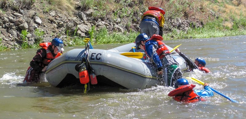 raft guide trainees climb back onboard their raft