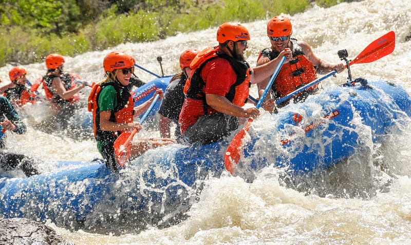 First-time rafters paddling a Class III rapid with an Echo Canyon guide on the Arkansas River near Cañon City, Colorado