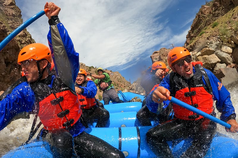 Bachelor party group paddling Class IV rapids through the Royal Gorge on the Arkansas River with Echo Canyon River Expeditions