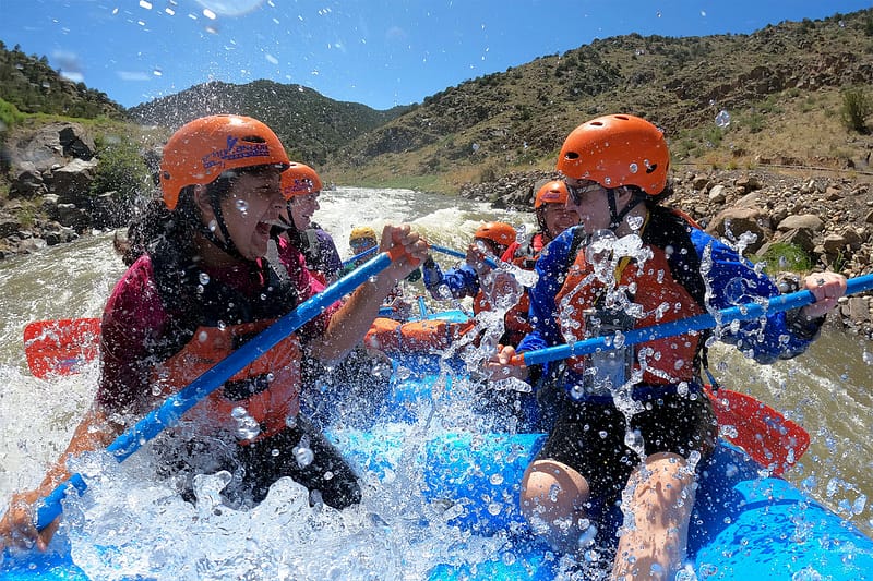 Family laughing and splashing in a raft in Bighorn Sheep Canyon
