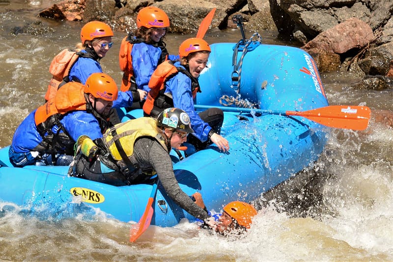 raft guide pulling a rafter back into a raft