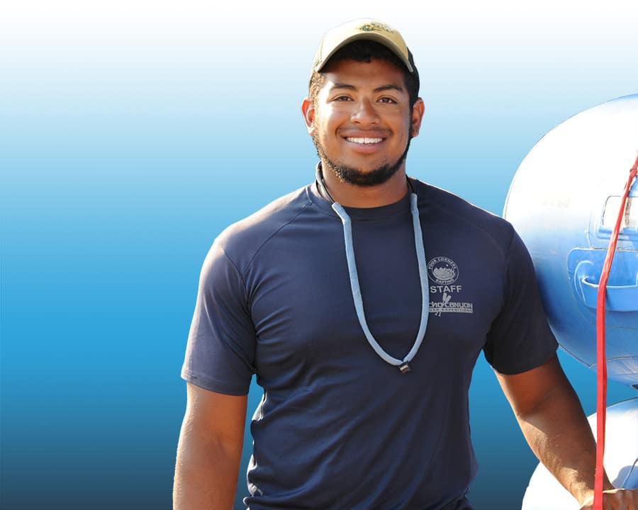 An Echo Canyon rafting guide standing next to stacked rafts.