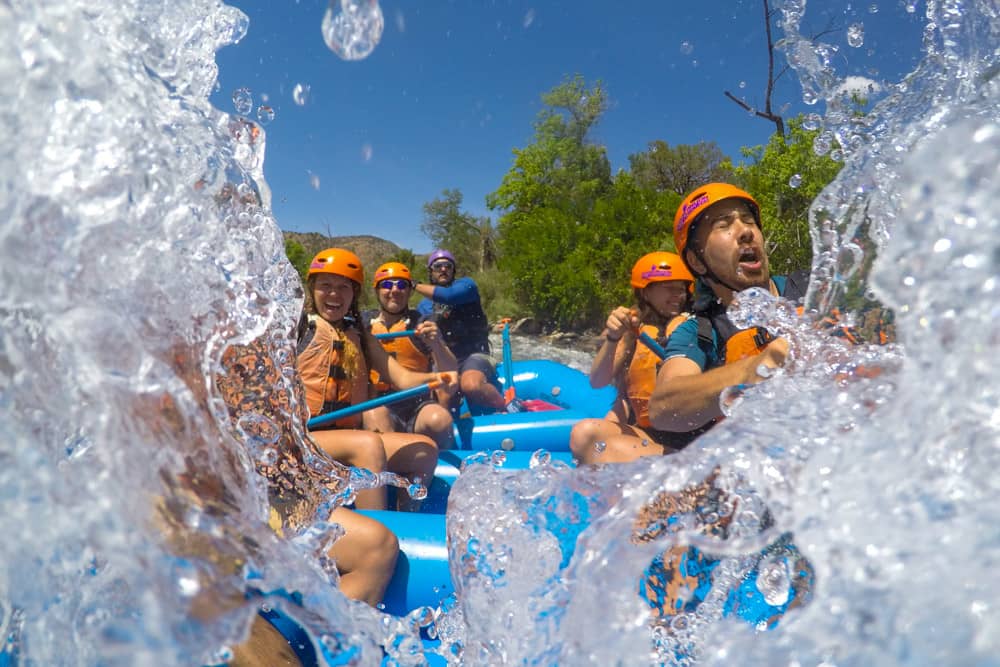 Rafters take on a splash while paddling Texas Creek Rapid