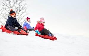 kids sledding a hill