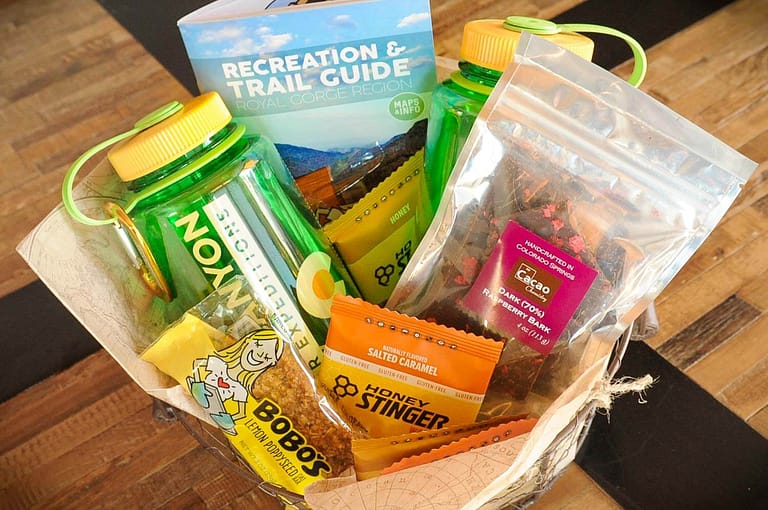 Adventure basket with water bottles, energy bars, chocolate, and a recreation trail guide